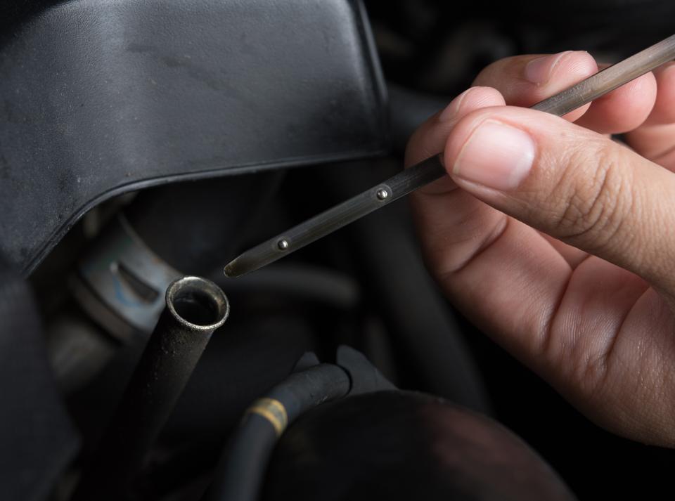 A hand holding a dipstick, close up