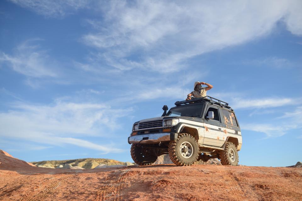 An off-road SUV parked on a red rock ridge