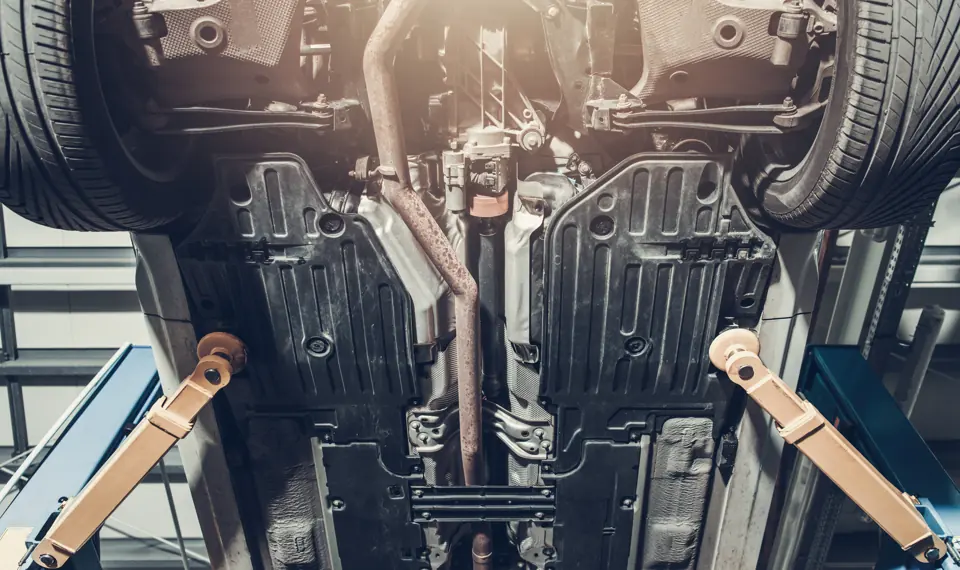 The underside of a car raised on a two-post lift